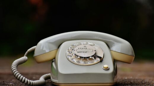 gray rotary telephone on brown surface